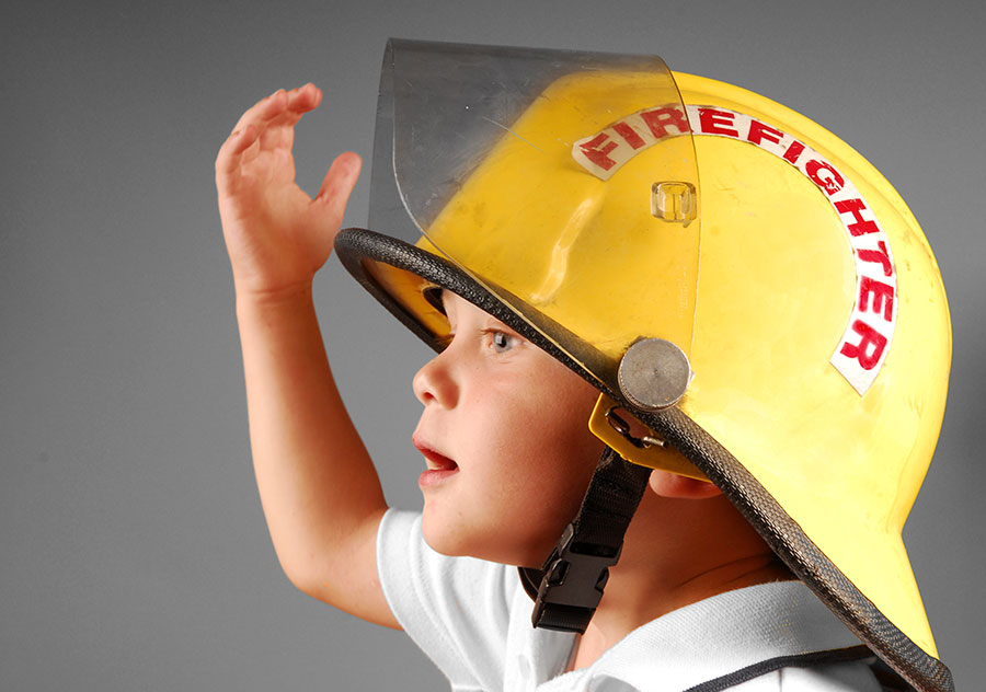 Little kid with a fire helmet onm