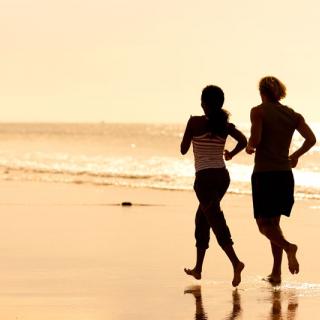 2 people running on beach