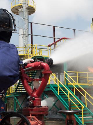 Industrial firefighter spraying water from a deck gun