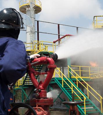 Industrial firefighter spraying water from a deck gun