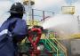 Industrial firefighter spraying water from a deck gun